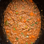 overhead shot of cooked chuck wagon stew in a black slow cooker