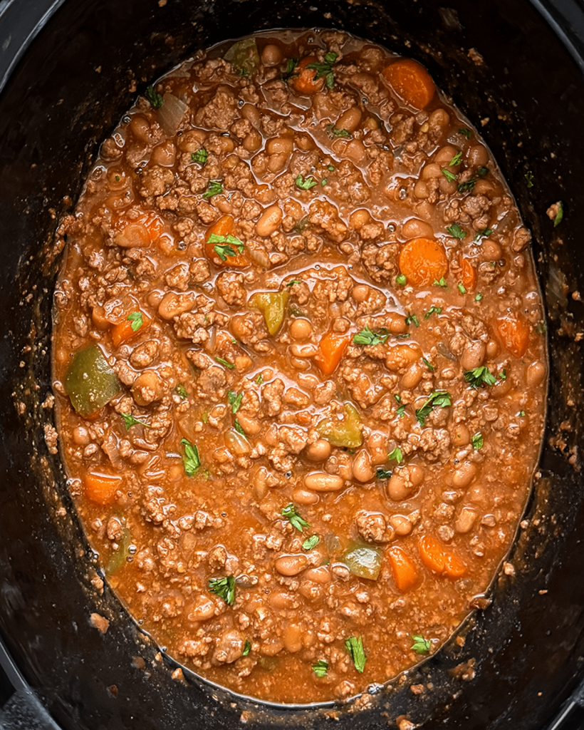 overhead shot of cooked chuck wagon stew in a black slow cooker