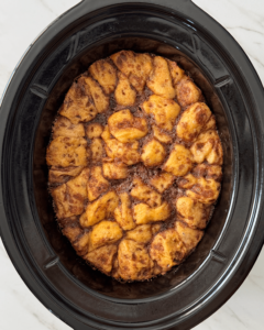 overhead shot of cooked Cinnamon Roll Casserole in a black slow cooker