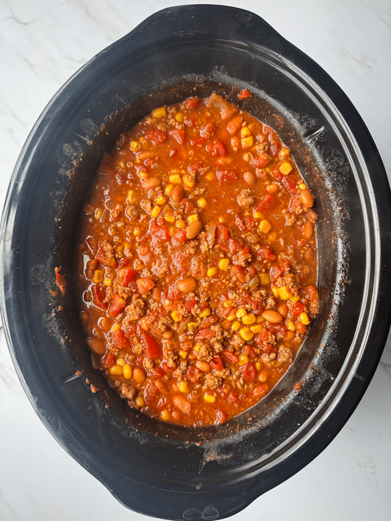 overhead shot of cooked taco chili in a black slow cooker