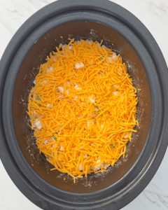 overhead shot of uncooked Cheesy Breakfast Potatoes in a black slow cooker