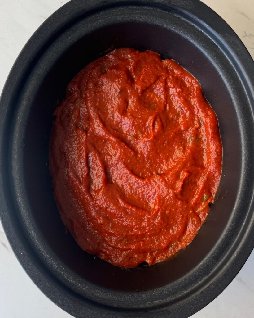 overhead shot of uncooked Dolly's 5-Layer Dinner in a black slow cooker