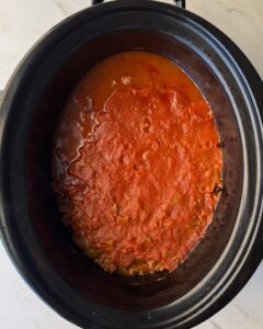 overhead shot of cooked Dolly's 5-Layer Dinner in a black slow cooker