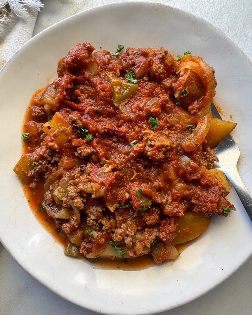 overhead shot of cooked Dolly's 5-Layer Dinner on a white plate with a silver fork