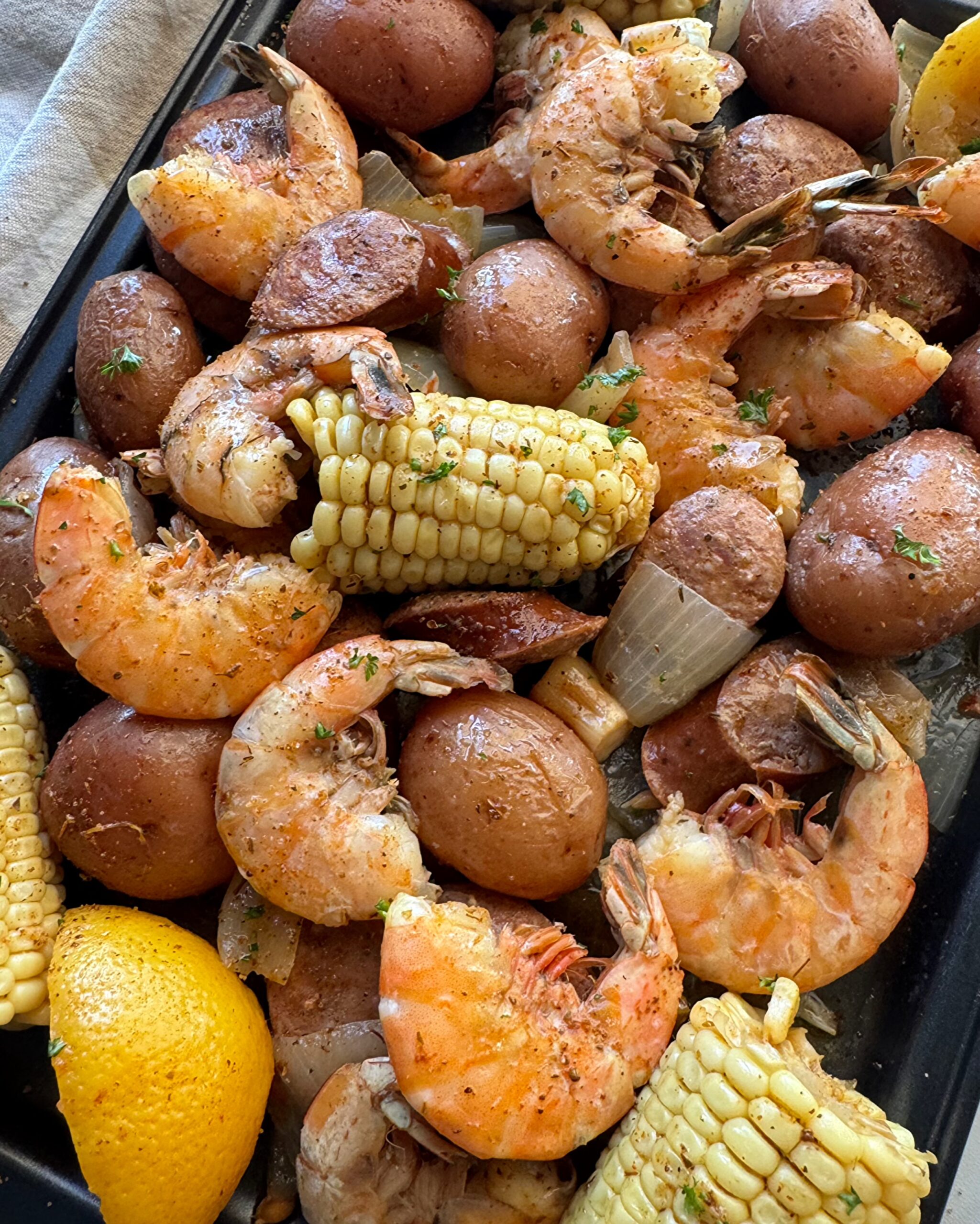 close up shot of slow cooker Cajun shrimp boil on a baking sheet