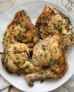 4 chicken leg quarters on a white plate