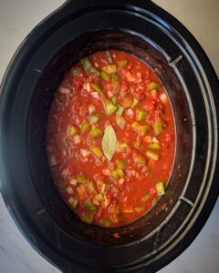 overhead shot of uncooked shrimp Creole in a black slow cooker