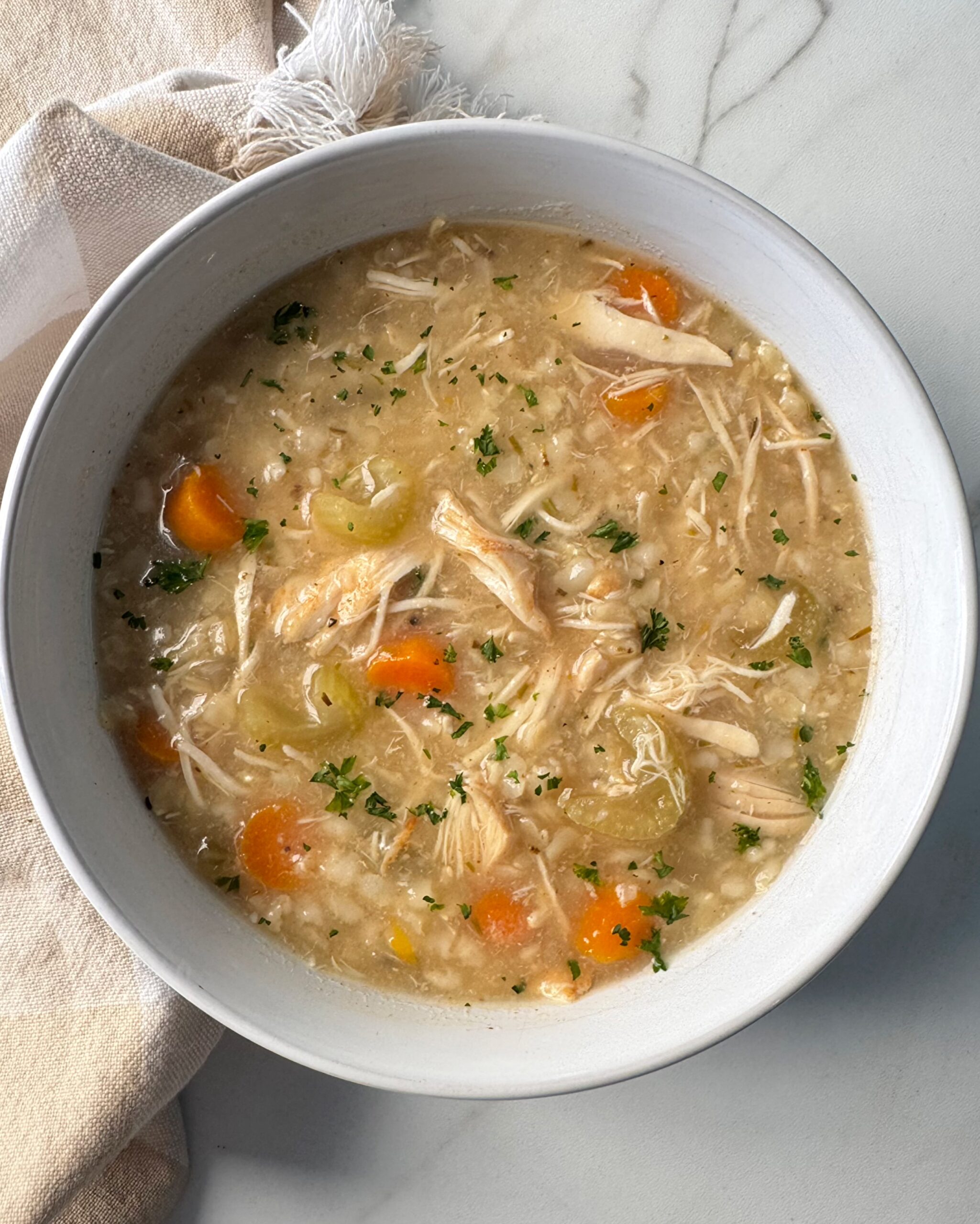 overhead shot of cooked Chicken and Rice Soup in a whit bowl