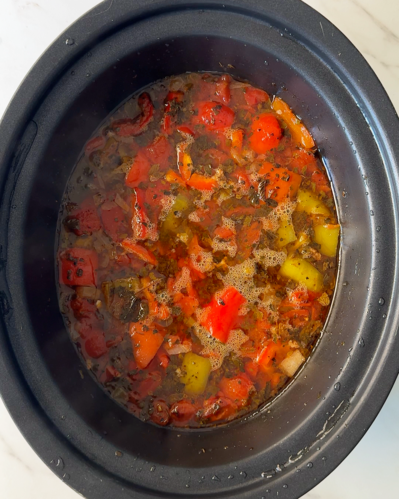 overhead shot of cooked Stuffed Pepper Soup in a black slow cooker