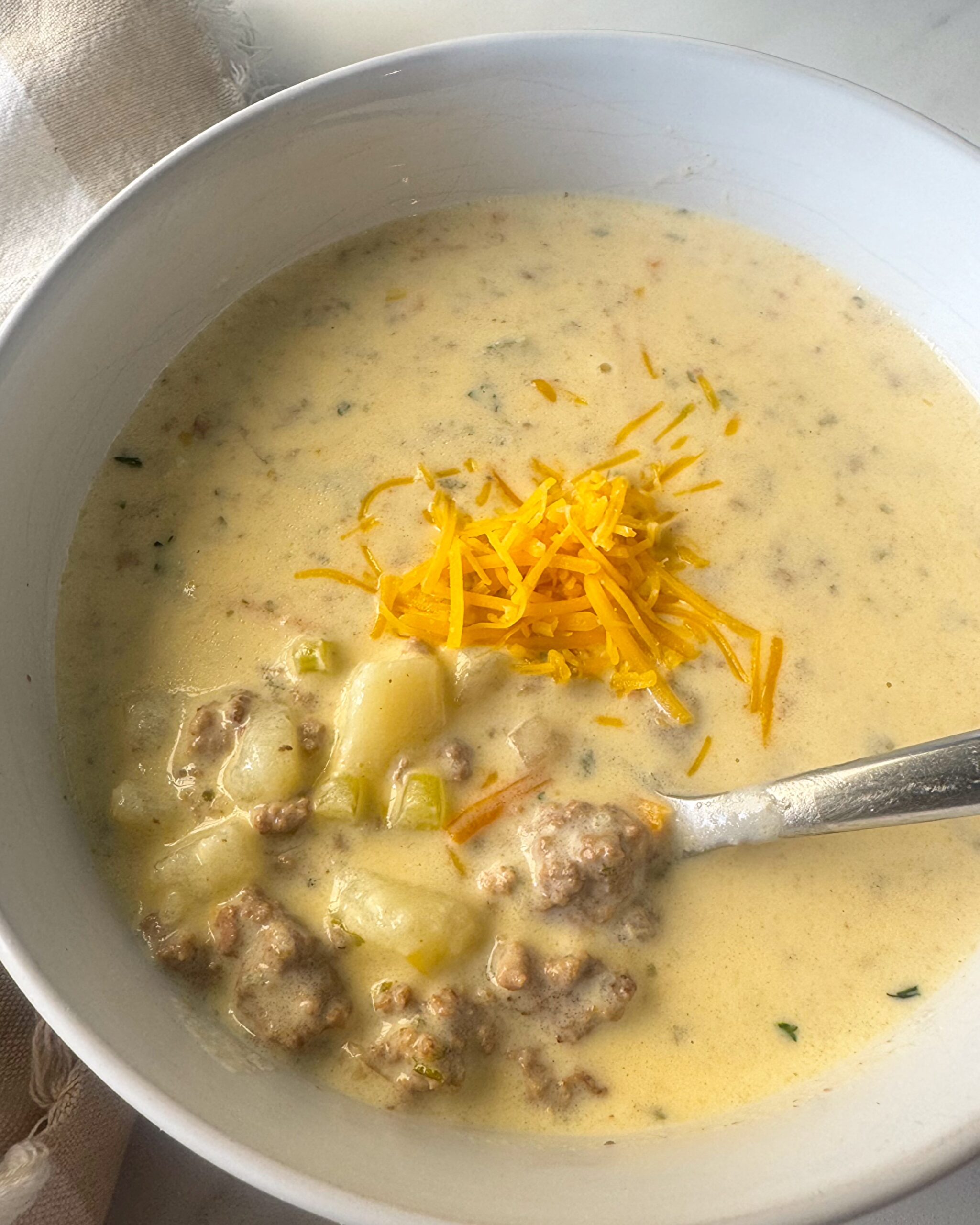 overhead shot of cheeseburger soup in a white bowl
