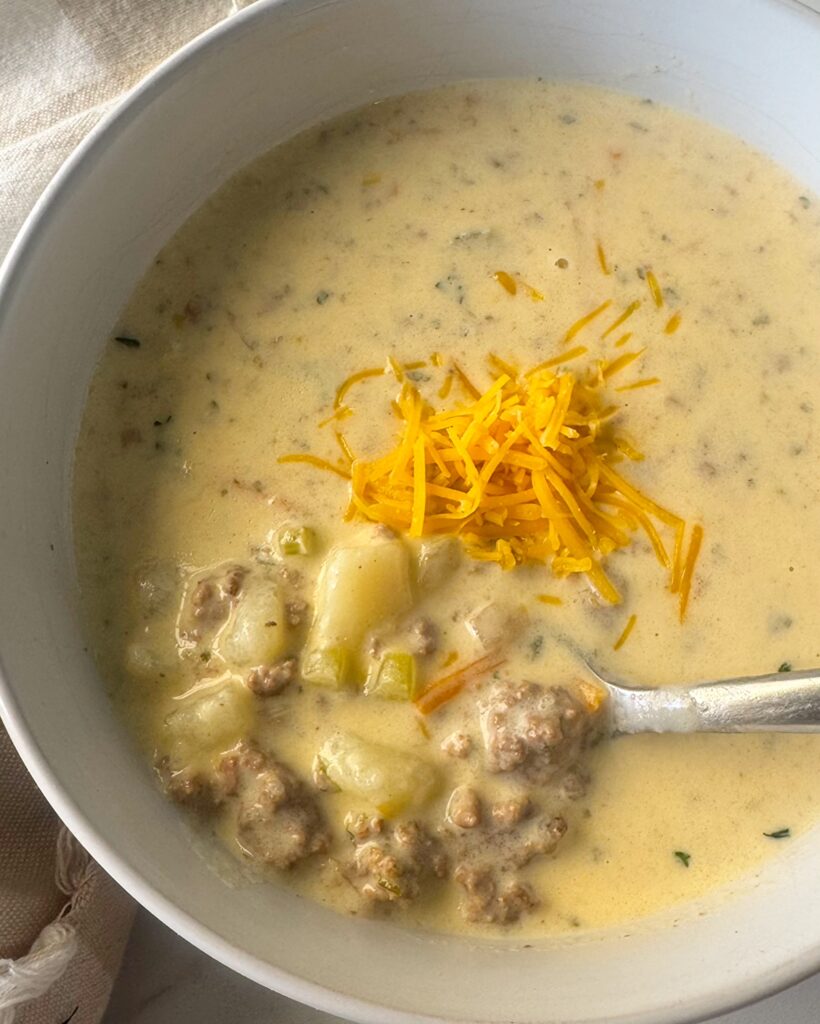 overhead shot of cheeseburger soup in a white bowl