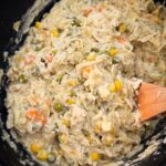 overhead shot of cooked chicken and noodles in a black slow cooker