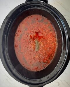 overhead shot of cooked ingredients for American Goulash in a black slow cooker