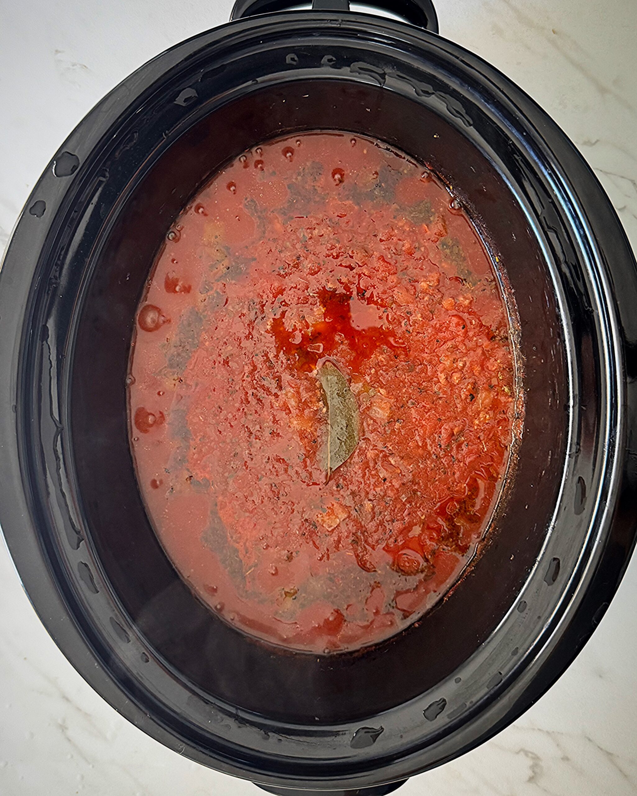 overhead shot of cooked ingredients for American Goulash in a black slow cooker