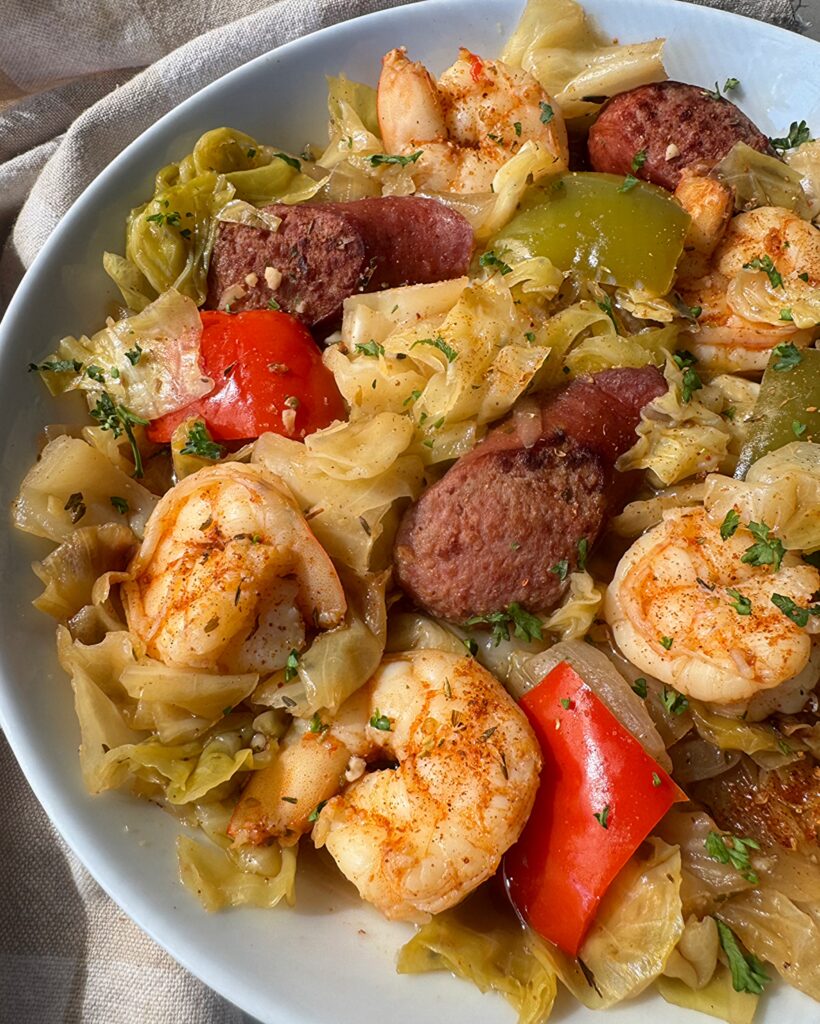 close up show of Crockpot Cajun Cabbage Sausage Shrimp on a white plate