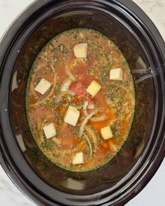 overhead shot of uncooked cube steak in a black slow cooker