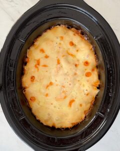 overhead shot of cooked Reuben Casserole in a black slow cooker