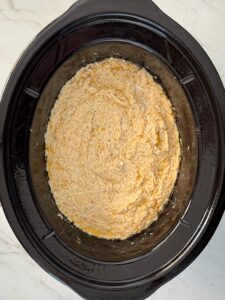 overhead shot of cooked crockpot crab in a black slow cooker