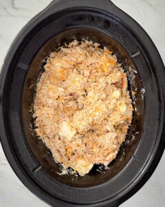 overhead shot of uncooked crockpot crab in a black slow cooker