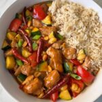 overhead shot of cooked Kung Pao Chicken (Panda Express Copycat) on a white plate with white rice