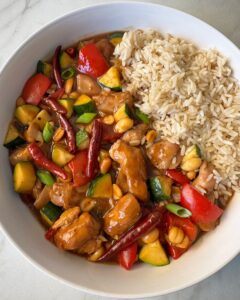 overhead shot of cooked Kung Pao Chicken (Panda Express Copycat) on a white plate with white rice
