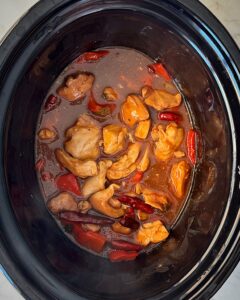 overhead shot of cooked Kung Pao Chicken (Panda Express Copycat) in a black slow cooker