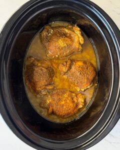 overhead shot of cooked North African chicken in a black slow cooker