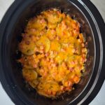 overhead shot of cooked Scalloped Potatoes and Ham in a black slow cooker
