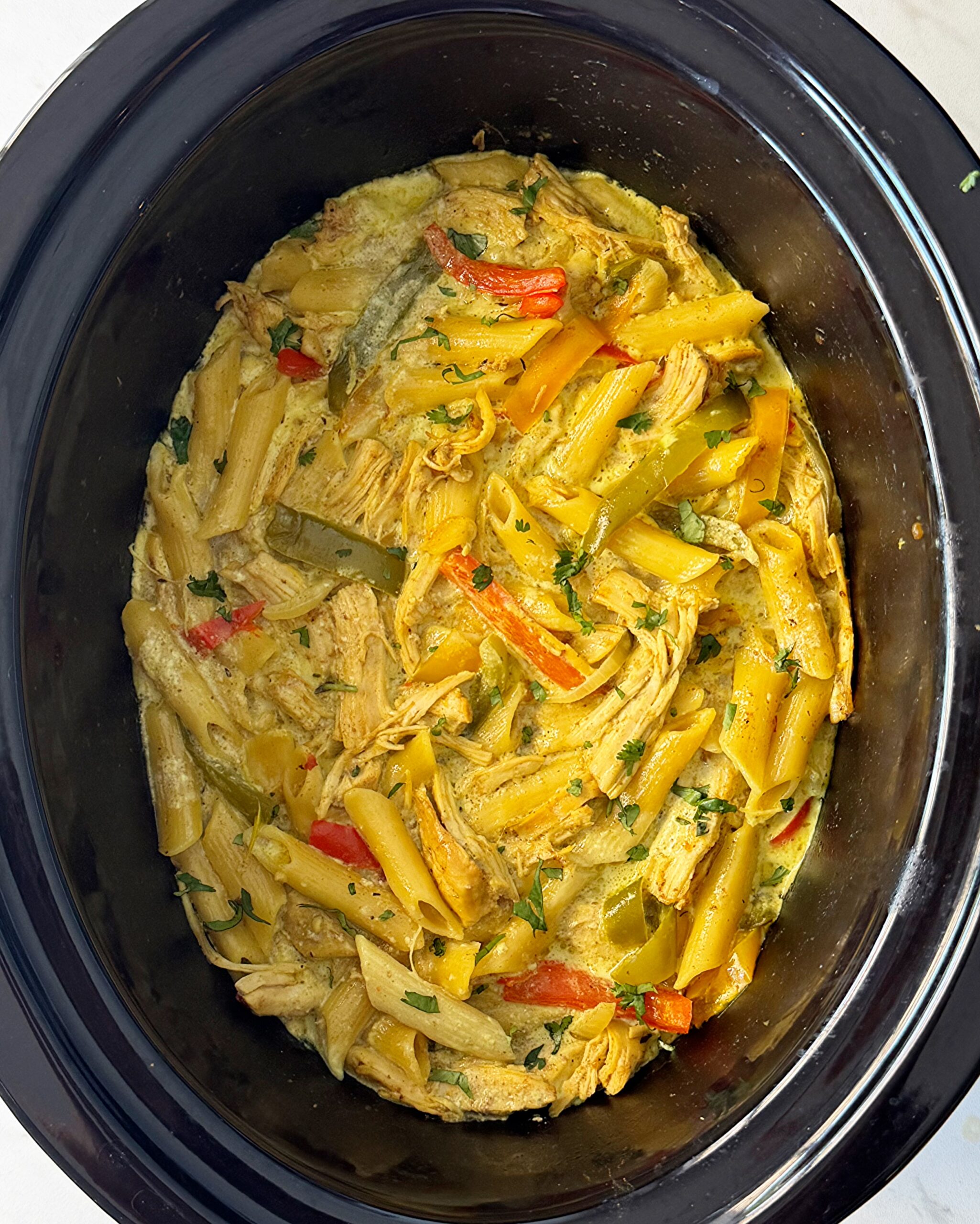 overhead shot of cooked Rasta pasta in a black slow cooker