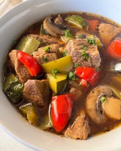 close up shot of beef kebab soup in a white bowl