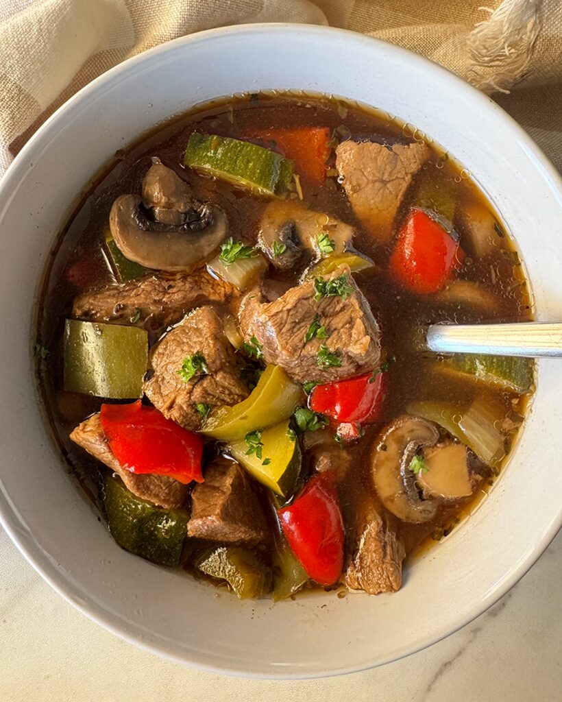 overhead shot of beef kebab soup in a white bowl