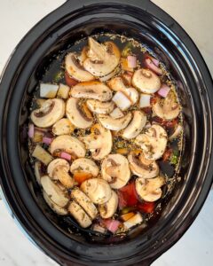 overhead shot of uncooked beef kebab soup in a black slow cooker