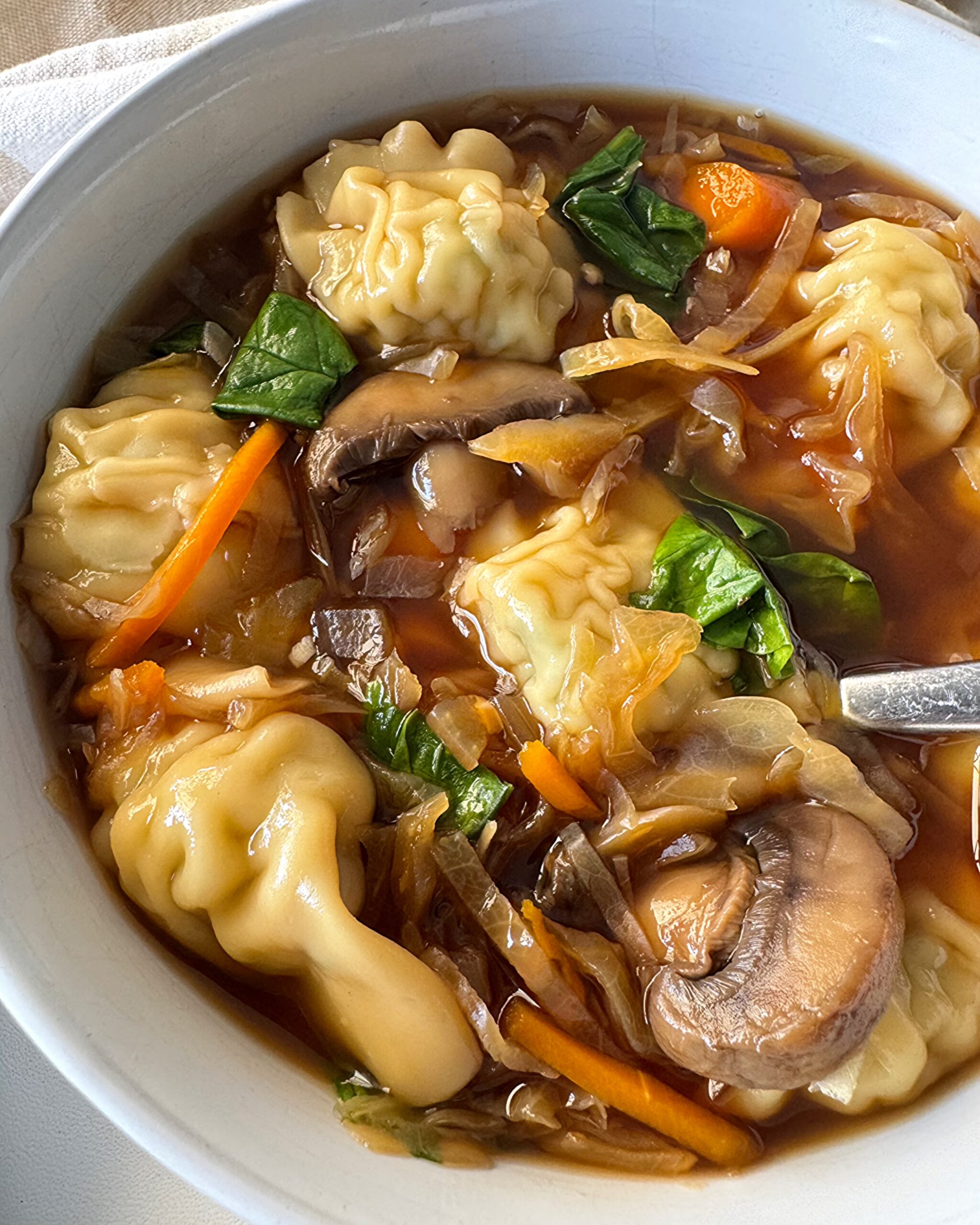 close up shot of Slow Cooker Potsticker Soup in a white bowl