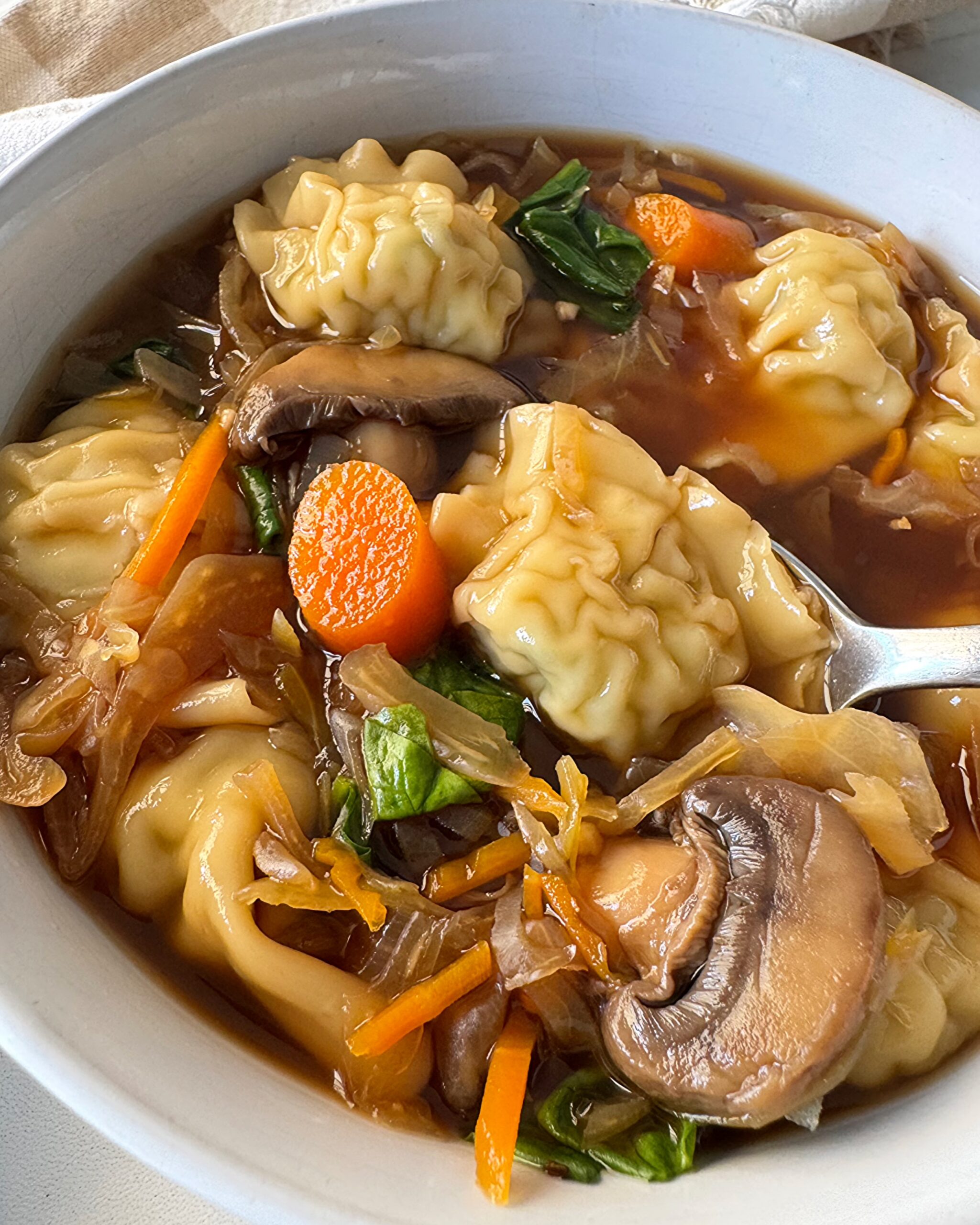 close up shot of Slow Cooker Potsticker Soup in a white bowl