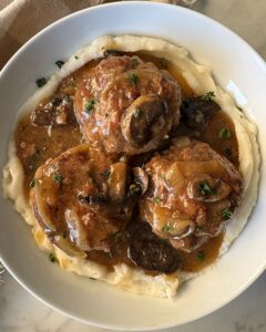 overhead shot of Slow Cooker Salisbury Steak on a white plate served over mashed potatoes